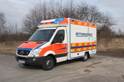 Abbildung zeigt einen weißen Rettungswagen in Kastenform der Marke Mercedes Benz